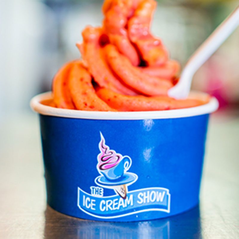 A blue bowl of ice cream with an orange swirl.